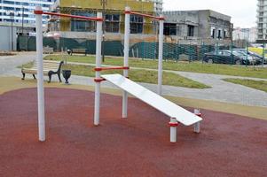 una nueva y moderna área de entrenamiento al aire libre con máquina de ejercicios para la prensa en una nueva área de la ciudad en el patio del nuevo edificio foto