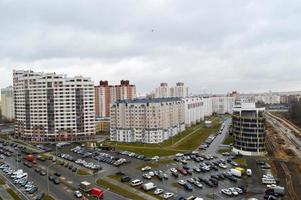 vista superior de una gran ciudad moderna con casas, edificios de varios pisos y arquitectura, estacionamiento y muchos autos