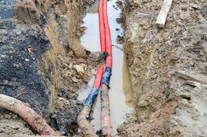 Large red plastic corrugated pipes with wires for a transformer substation at a construction site during a repair in a new underground community photo