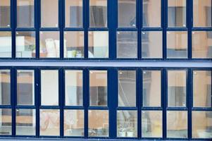 hermosas y modernas ventanas de fibra de vidrio azul de la pared de la fachada de una moderna casa de construcción de rascacielos. fondo, textura foto