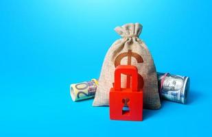 Dollar money bag and red padlock. Sanctions and Restrictions. Freezing of assets, seizure of savings and property. Unavailability of loans, low credit score. Fund reservation. Transaction restrictions photo