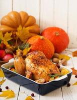 pavo asado adornado con arándanos sobre una mesa de estilo rústico decorada con calabazas, naranjas, manzanas y hojas de otoño. día de Gracias.