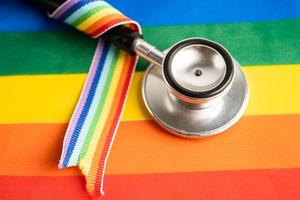 Red stethoscope on rainbow flag background, symbol of LGBT pride month  celebrate annual in June social, symbol of gay, lesbian, bisexual, transgender, human rights and peace. photo
