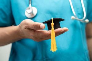 el estudio de un médico asiático aprende con un sombrero de brecha de graduación en la sala del hospital, un concepto de medicina inteligente y brillante. foto