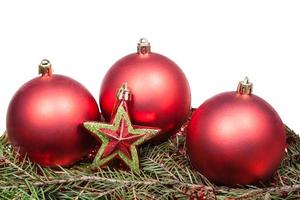 Bolas de Navidad rojas y estrellas en la rama de abeto verde foto