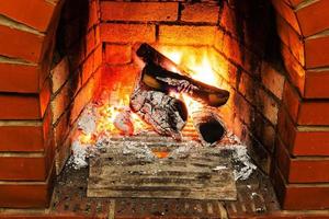 ash, coal and burning firewood in fireplace photo