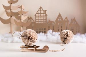 decoración casera navideña de bricolaje: bola de papel en trineo, árbol de cartón y casa. festivo hecho a mano. foto