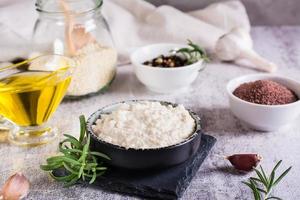 Tahini sauce from sesame seeds in a bowl and ingredients for cooking on the table photo