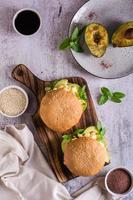 Hamburger with avocado, scrambled eggs and basil on a board. Healthy food. Top and vertical view photo