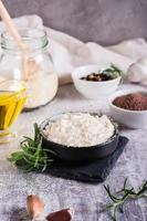 Tahini sauce from sesame seeds in a bowl and ingredients for cooking on the table. Vertical view photo