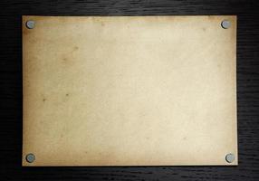 Old paper on the dark wood background photo