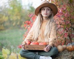 niña en el heno con calabazas foto