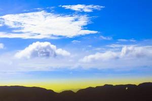 árbol verde y montañas en el cielo azul con nubes, hermoso fondo de puesta de sol foto