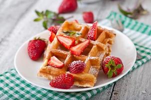 Belgium waffles with strawberries and mint  on white plate photo