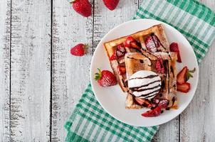 Belgium waffles with strawberries and ice cream  on white plate photo