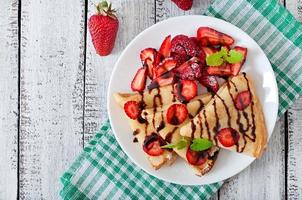 tortitas con fresas y chocolate decoradas con hojas de menta foto