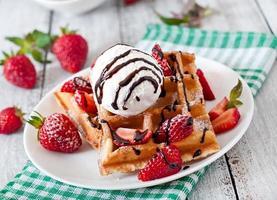 Belgium waffles with strawberries and ice cream  on white plate