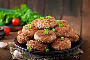 Juicy delicious meat cutlets on a wooden table in a rustic style. photo