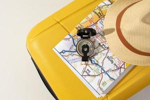 traveler accessories on yellow bag,map, hat, compass photo