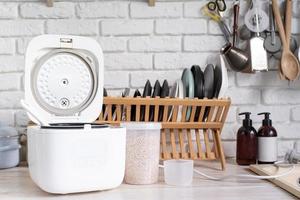 Electric rice cooker on wooden counter-top in the kitchen photo