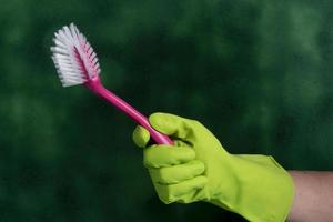 hand with protective glove holding packaging of cleaning products used for home hygiene photo