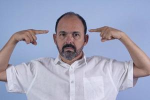 Portrait of 60 years old bearded man on blue background photo