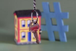 House symbol with metal key and property miniature, symbolizing home ownership photo