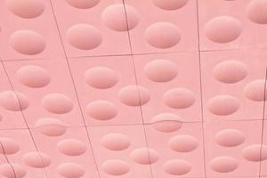 The close-up of pink detailed sphere texture reverse side of the plastic tile. Rough embossed lattice. Concept of design. Wall decoration interior. Relief balls geometric pattern. Flatlay, mock up photo