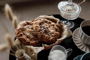 desayuno estético. café con leche, té con leche, azúcar, almendra, tortas de almendra, bizcochos, mazapanes y hojaldres. desayuno británico en un hogar acogedor. estado de ánimo de otoño. foto