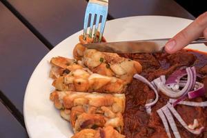 A man eats beef goulash with Czech dumplings with a knife and fork. photo