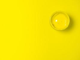 A jar of yellow paint on a yellow background. Bank of gouache. Bright background.  Artist's workshop.