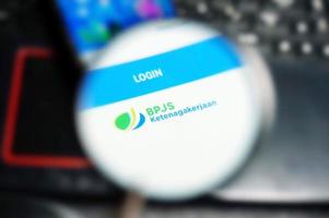 BPJS Employment online application logo under  magnifying glass. Selective Focus photo