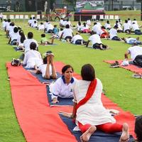 New Delhi, India, June 21 2022 - Group Yoga exercise session for people at Yamuna Sports Complex in Delhi on International Yoga Day, Big group of adults attending yoga class in cricket stadium photo