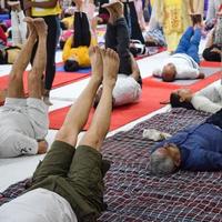 New Delhi, India, June 19 2022 -Group Yoga exercise session for people of different age groups in Balaji Temple, Vivek Vihar, International Yoga Day, Big group of adults attending yoga class in temple photo