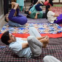 New Delhi, India, June 19 2022 -Group Yoga exercise session for people of different age groups in Balaji Temple, Vivek Vihar, International Yoga Day, Big group of adults attending yoga class in temple photo