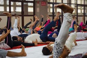 New Delhi, India, June 19 2022 -Group Yoga exercise session for people of different age groups in Balaji Temple, Vivek Vihar, International Yoga Day, Big group of adults attending yoga class in temple photo