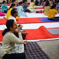 New Delhi, India, June 19 2022 -Group Yoga exercise session for people of different age groups in Balaji Temple, Vivek Vihar, International Yoga Day, Big group of adults attending yoga class in temple photo