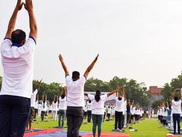 sesión de ejercicios de yoga en grupo para personas de diferentes grupos de edad en el estadio de cricket en delhi el día internacional del yoga, gran grupo de adultos que asisten a la sesión de yoga foto