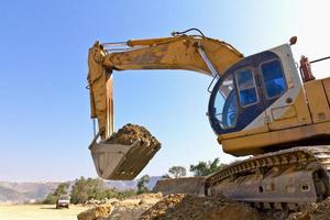 Back hoe vehicle on a pile of dirt photo