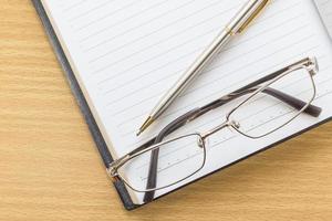 Notebook open blank page and Eyeglasses photo