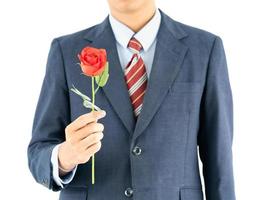 Businessman in suit with red rose on white photo