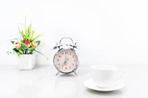 Silver alarm clock and coffee cup photo