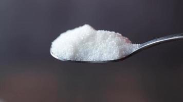 Spoon full of white granulated sugar close up video