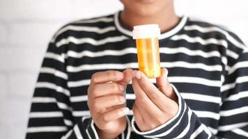 Man in striped shirt holds pill bottle video