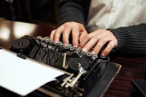 Man using typewriter closeup photo