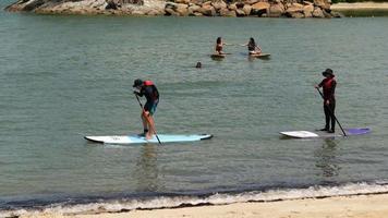 pessoas fazendo stand up paddle na costa video