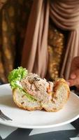 Thunfisch-Sandwich mit offenem Gesicht, das von einem weißen Teller gegessen wird video