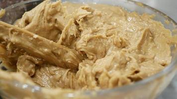 Bowl of peanut butter close up with a wooden spoon video