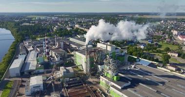 Kreisflug um Rohre mit weißem Rauch des Sägewerks des Holzbearbeitungsunternehmens. luftverschmutzungskonzept auf industrielandschaft video