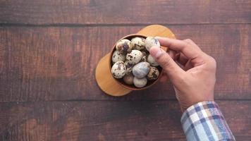 Man picks quail egg from bowl video